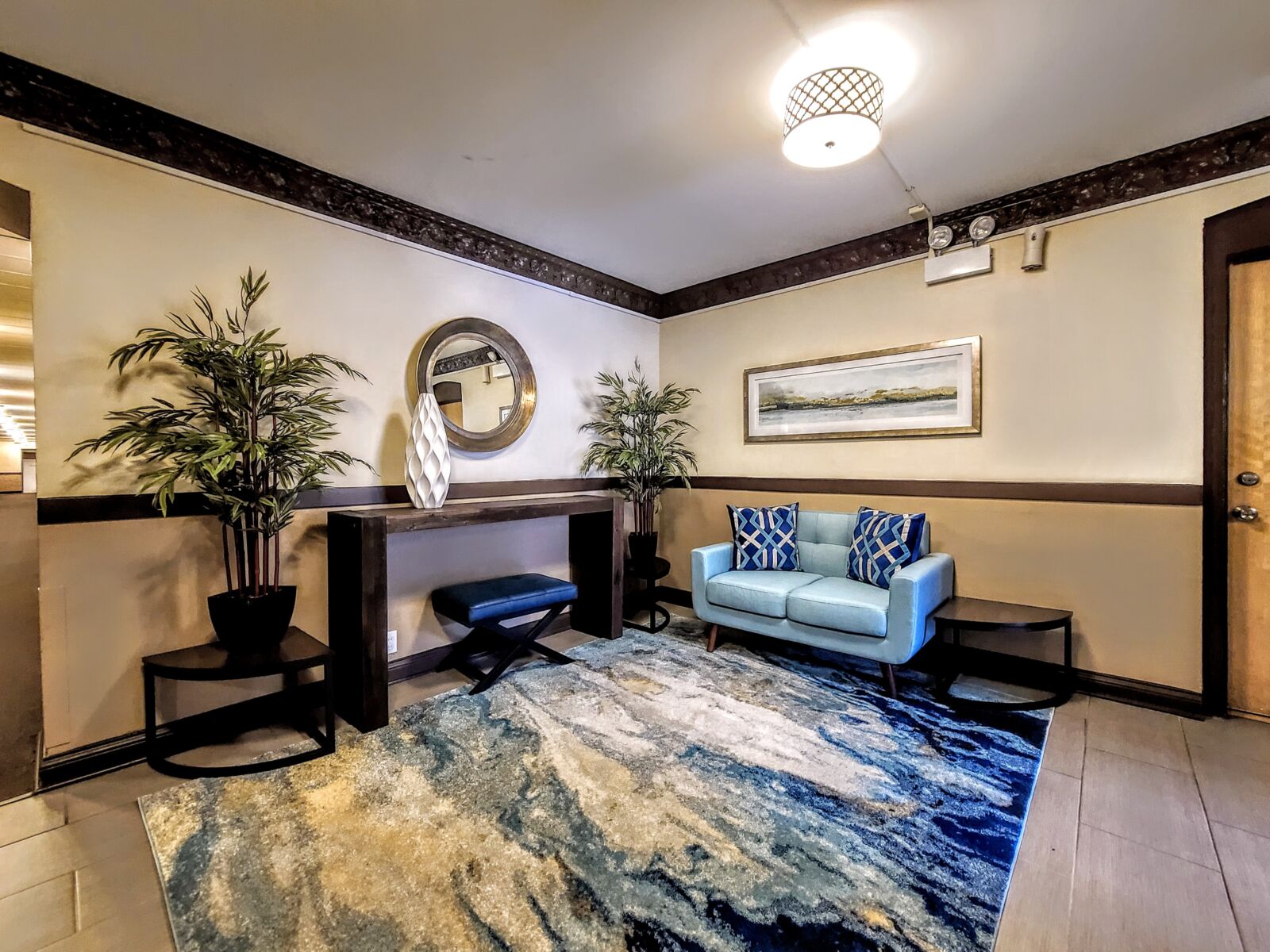 The lobby of 536 West Arlington Place, with a blue loveseat, patterned pillows, and a modern cons...