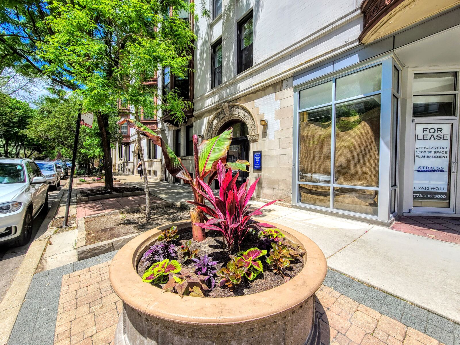 A large round planter filled with colorful flowers outside 600–606 West Surf Street in Chicago’s ...