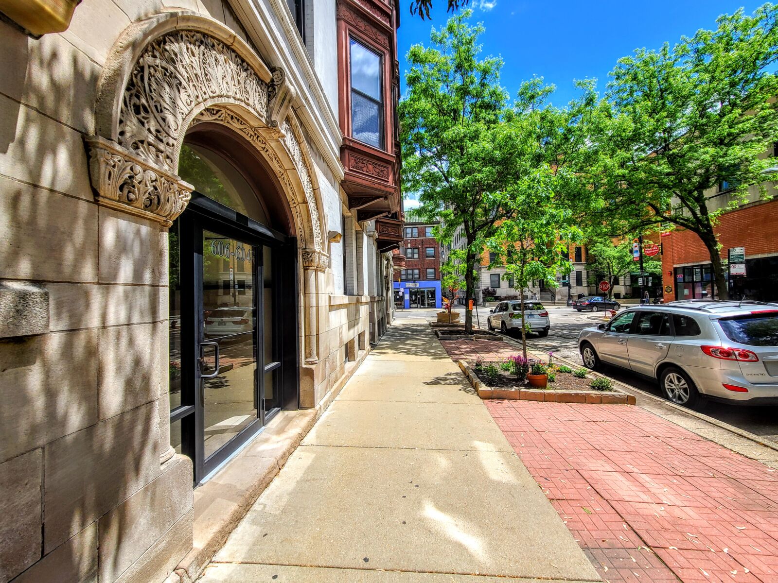 Tree-lined sidewalk at 600–606 West Surf Street in Chicago’s Lakeview neighborhood, with the orna...