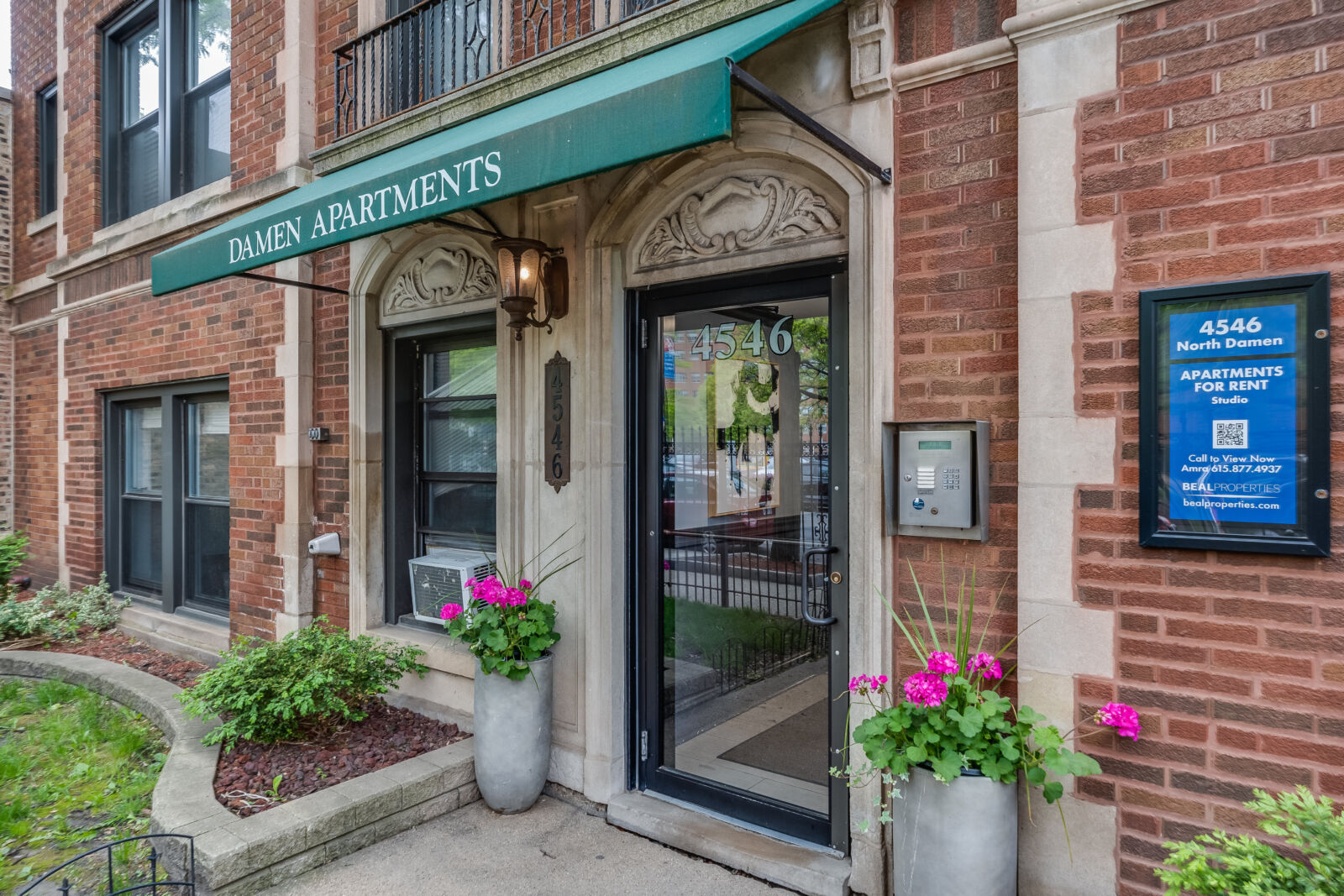 Close-up of the entrance at 4546 North Damen Avenue, showing the green “Damen Apartments” awning,...