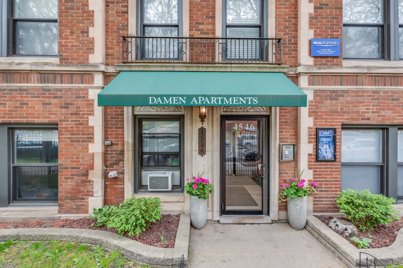 Street-level view of 4546 North Damen Avenue from the sidewalk, with mature trees, parked cars, a...