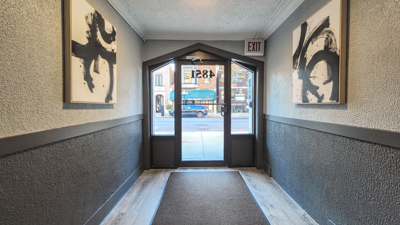 Hallway at 4851 North Damen Avenue in Chicago’s Lincoln Square neighborhood, with gray walls, bla...