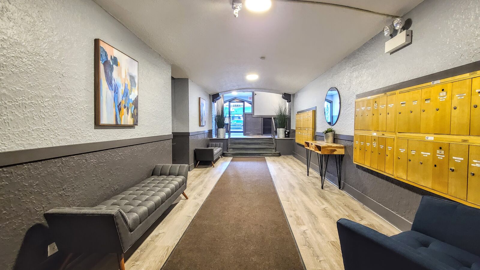 Lobby at 4851 N Damen Ave (Lincoln Square) with wood-look floors, seating, and rows of yellow mai...