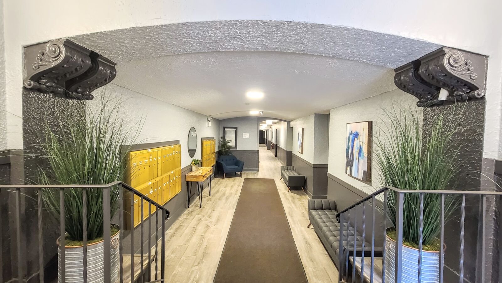 Lobby at 4851 N Damen Ave (Lincoln Square) viewed from the stair landing, showing planters, seati...