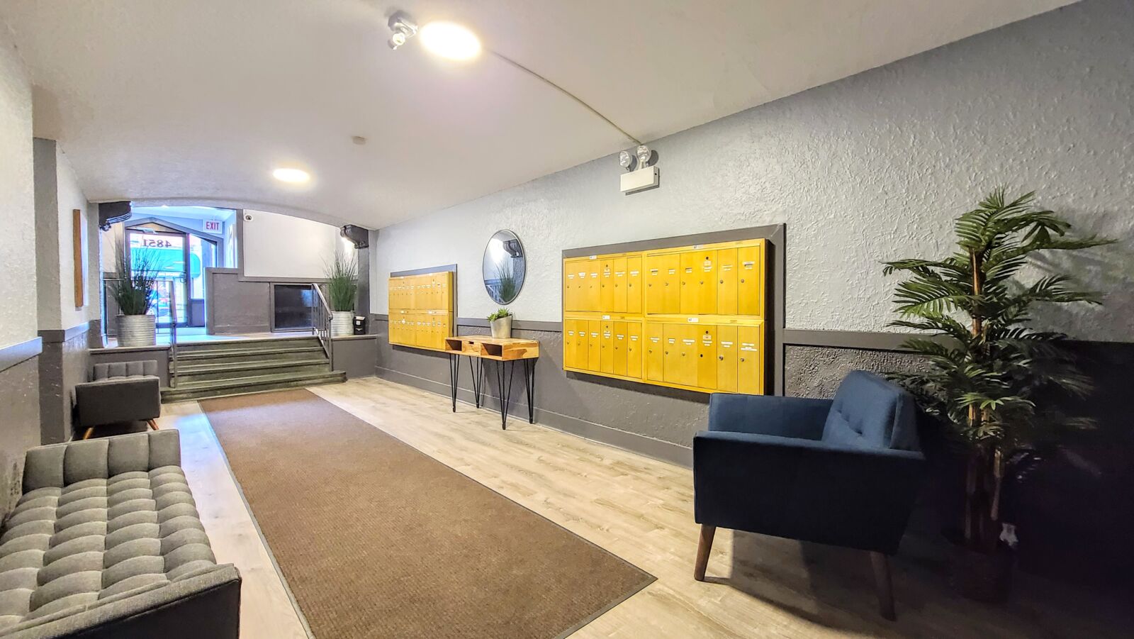 Lobby at 4851 N Damen Ave (Lincoln Square) featuring seating areas, plants, and dual walls of yel...